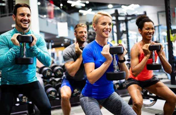 4 smiling people with weights