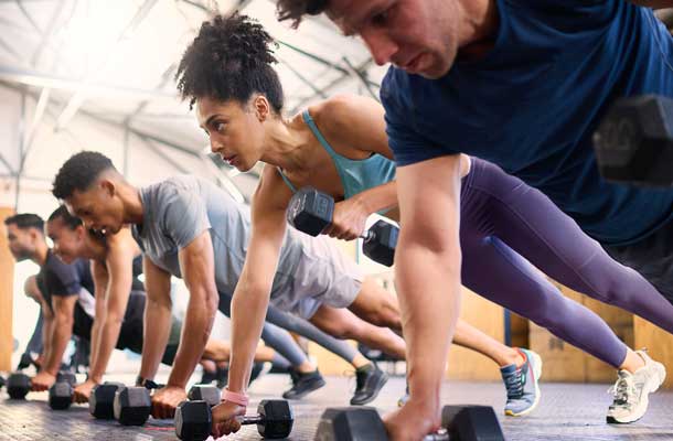 line up of people doing pushups with weights